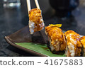 chopsticks holding salmon sushi roll 41675883