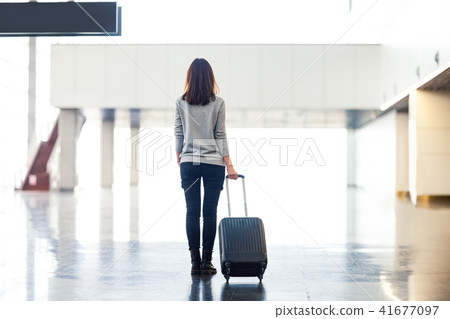 woman with suitcase in airport terminal 41677097