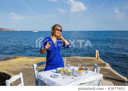 Young woman in a restaurant by the sea Young woman in a restaurant by the sea 41677401