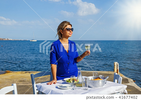 Young woman in a restaurant by the sea Young woman in a restaurant by the sea 41677402