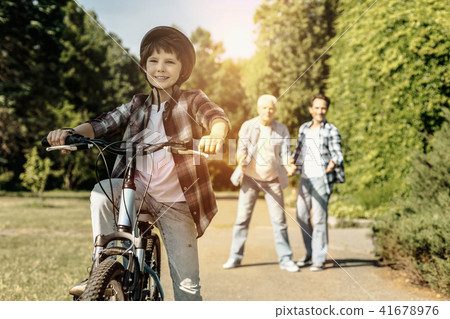 Boy riding his bicycle and wearing a casque Boy riding his bicycle and wearing a casque 41678976