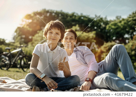 Boy showing thumb up and sitting with his dad Boy showing thumb up and sitting with his dad 41679422