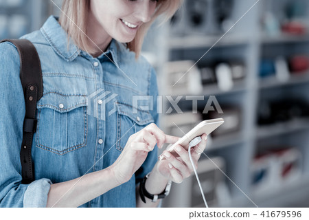 Careful customer using a tiny smartphone Careful customer using a tiny smartphone 41679596
