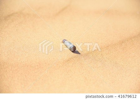 Old rusty cartridge case in sand close Old rusty cartridge case in sand close 41679612