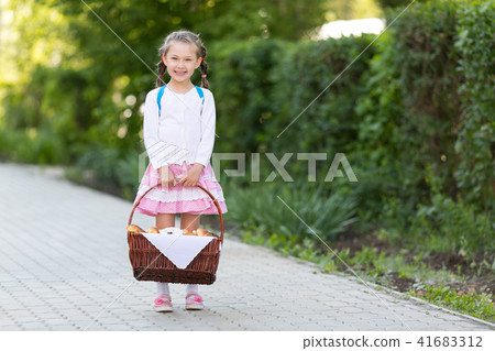 A child with a basket of bread is on the road. A child with a basket of bread is on the road. 41683312