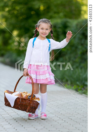 A child with a basket of bread is on the road. 41683313