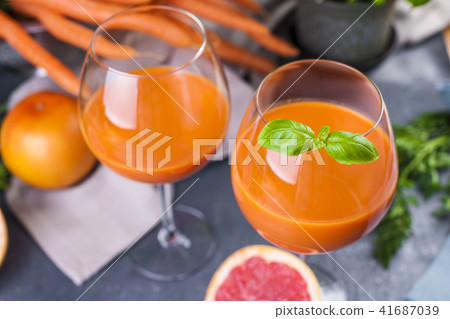 Juice from fresh carrots and basil in a glass, vitamin drink for a healthy diet. Copy space Juice from fresh carrots and basil in a glass, vitamin drink for a healthy diet. Copy space 41687039