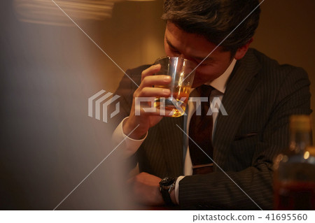 A businessman drinking at a bar A businessman drinking at a bar 41695560