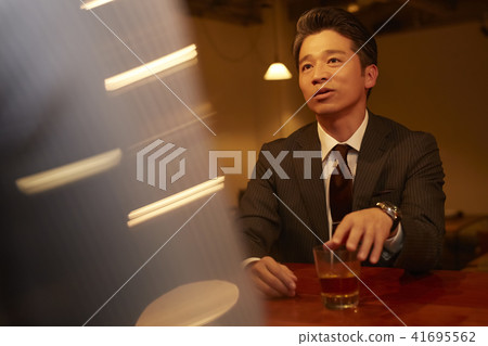 A businessman drinking at a bar A businessman drinking at a bar 41695562