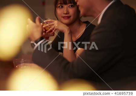 Men and women drinking at a bar 41695739