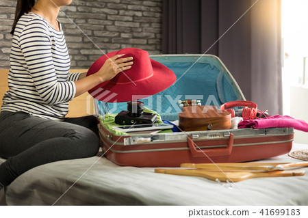 Woman hand packing a luggage for a new journey and travel for a Woman hand packing a luggage for a new journey and travel for a 41699183