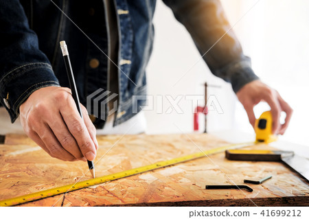 Carpenter working carefully looking at the plans work in carpent 41699212