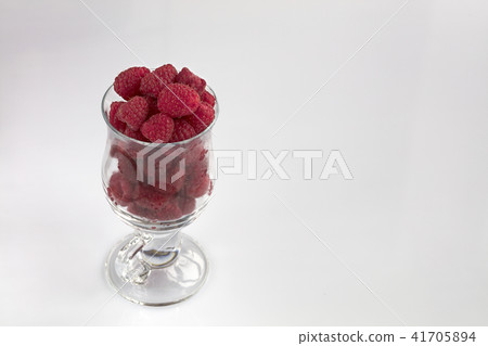 Raspberries in a clear glass on a light background Raspberries in a clear glass on a light background 41705894