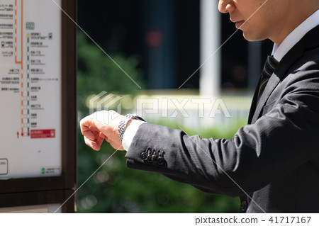 A businessman waiting for a bus A businessman waiting for a bus 41717167