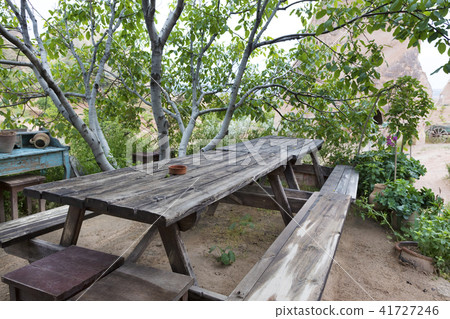 Old, weathered wooden table and benches in garden Old, weathered wooden table and benches in garden 41727246