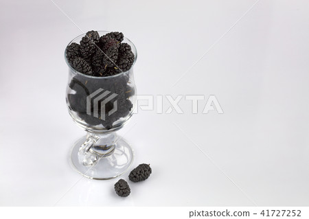 Red mulberry in a clear glass on light background Red mulberry in a clear glass on light background 41727252