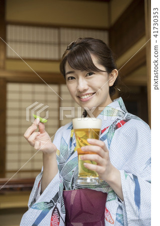 A woman in a yukata with a beer at an old private house A woman in a yukata with a beer at an old private house 41730353
