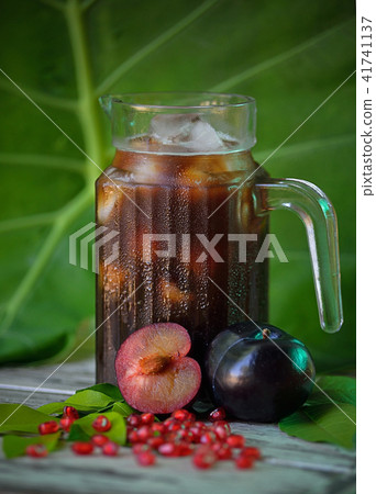 fresh plums juice on a white wooden background 41741137