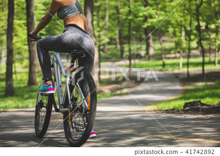 Sporty lady is exploring park on bicycle Sporty lady is exploring park on bicycle 41742892