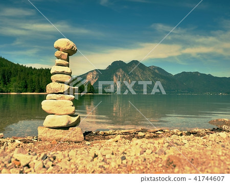 Balanced stone pyramide on shore of mountain lake. Balanced stone pyramide on shore of mountain lake. 41744607