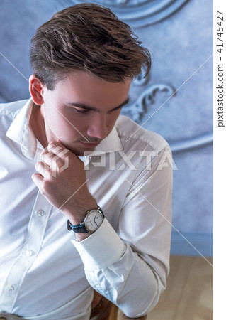 heartbroken groom in tuxedo with undone bowtie and open collar sits on chair with hand in pocket heartbroken groom in tuxedo with undone bowtie and open collar sits on chair with hand in pocket 41745427