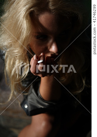 Young woman smoking in night park Young woman smoking in night park 41746299