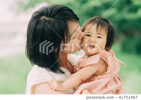 Young mother kissing baby's cheek Young mother kissing baby's cheek 41752467