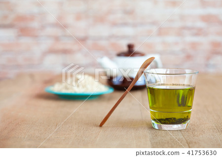 Oats flakes in wood spoon with hot green tea Oats flakes in wood spoon with hot green tea 41753630
