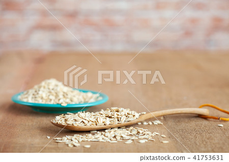 Oats flakes in wood spoon on wood table. Oats flakes in wood spoon on wood table. 41753631