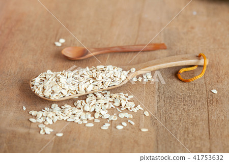 Oats flakes in wood spoon on wood table. Oats flakes in wood spoon on wood table. 41753632