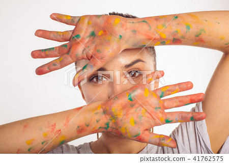 Close-up portrait girl covers face palms in paint Close-up portrait girl covers face palms in paint 41762575