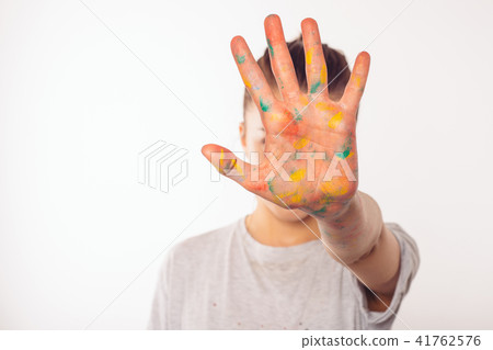 teenage girl covers her face with palm in paint 41762576