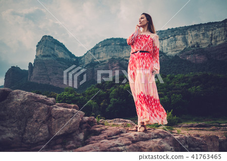 Young beautiful woman in red dress looking on mountains. Spain, Sant Roma de Sau. 41763465