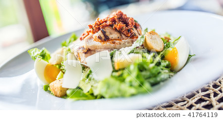 Salad caesar with grilled pieces of chicken breast 41764119