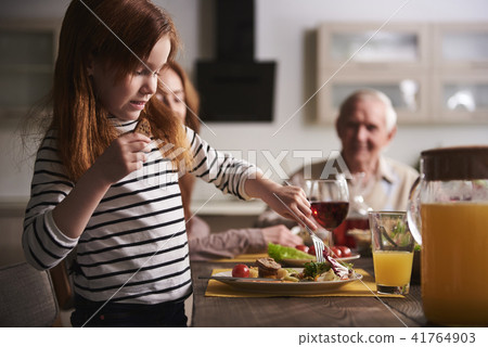 Small girl eating healthy meal at table Small girl eating healthy meal at table 41764903