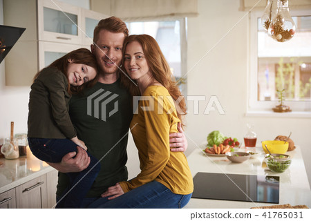 Delighted couple with daughter in kitchen before dinner Delighted couple with daughter in kitchen before dinner 41765031