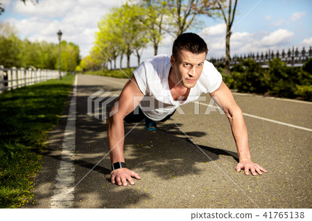 Ripped man is exercising on pectorals in nature 41765138