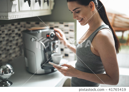 Content female preparing morning drink in kitchen 41765419