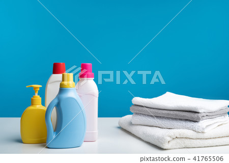 Range of various washing liquids standing near clean laundry 41765506