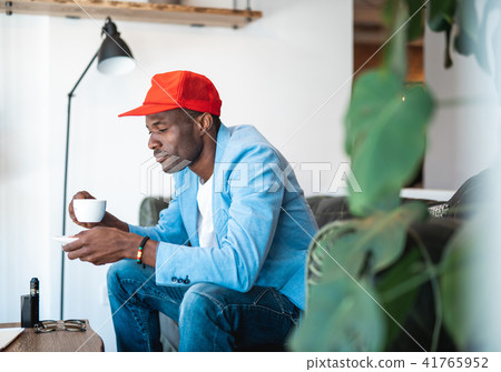 Thoughtful man tasting mug of beverage 41765952