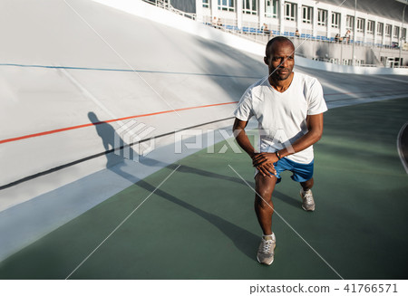 Glad athlete standing on track field Glad athlete standing on track field 41766571