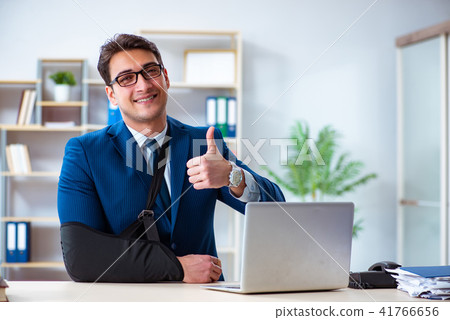 Businessman with broken arm working in office Businessman with broken arm working in office 41766656
