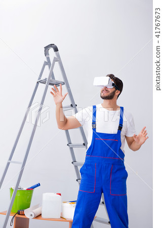 Man with VR glasses gluing wallpaper 41767673
