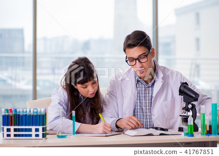 Two chemists working in lab experimenting 41767851