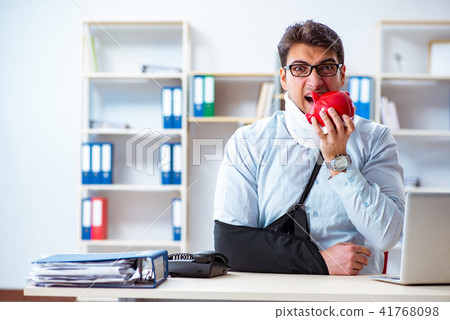 Businessman with broken arm working in office 41768098