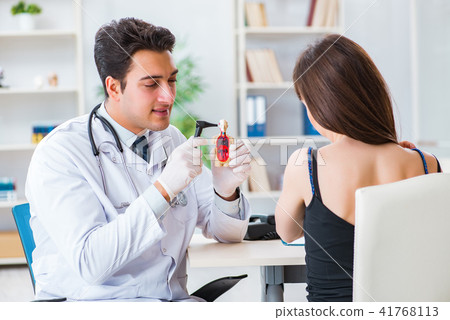 Doctor checking patients ear during medical examination 41768113