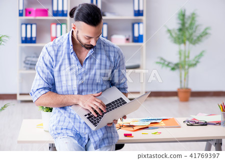 Young designer working in his studio on new project 41769397