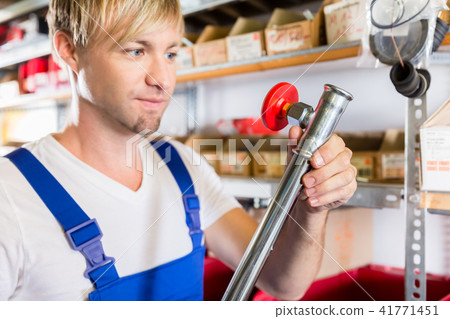 Close-up of the hand of a worker holding a metallic pipe during quality control 41771451