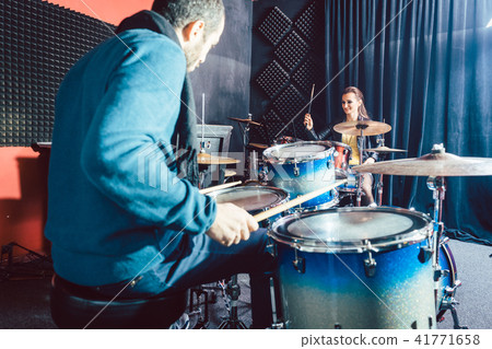 Woman receiving drum lessons from her music teacher Woman receiving drum lessons from her music teacher 41771658
