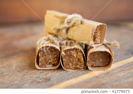 Homemade muesli bars with nuts and dried fruits on a wooden board Homemade muesli bars with nuts and dried fruits on a wooden board 41779975
